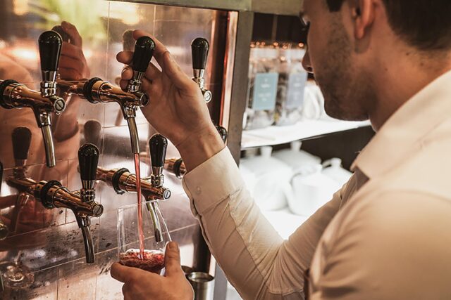 Galvin sommelier pouring an organic white wine during a sustainable tasting event.