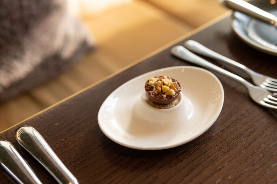 An elegant dining table prepared with a luxurious chocolate and hazelnut petit four