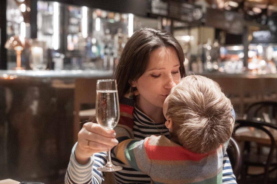 A mother and child sharing a joyful moment at the dining table, reflecting our warm and welcoming atmosphere.
