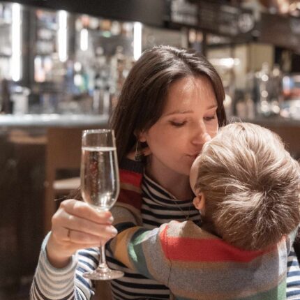 A mother and her child enjoying a celebratory glass of champagne during a special Sunday lunch.