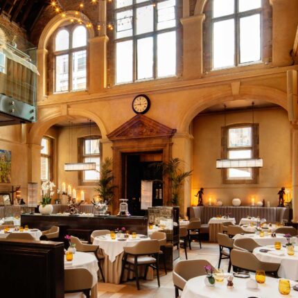 Warm ambient lighting accentuating the magnificent vaulted ceilings of our Grade II listed dining room during an elegant evening service.