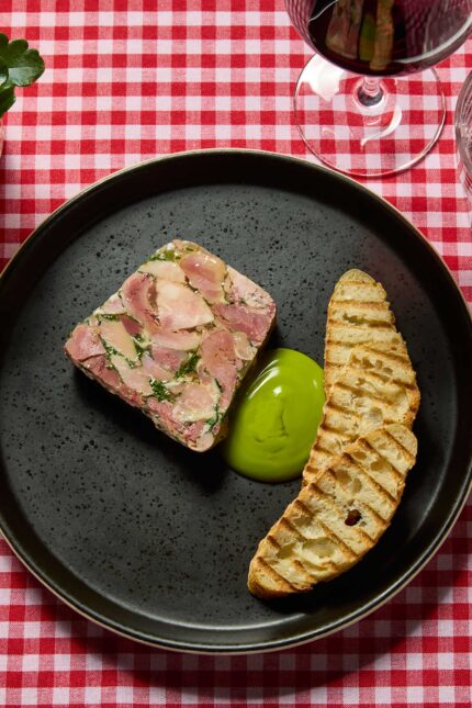 Rustic meat terrine served with toasted bread and green puree alongside a glass of red wine for Beaujolais Day at Galvin Bistrot & Bar.