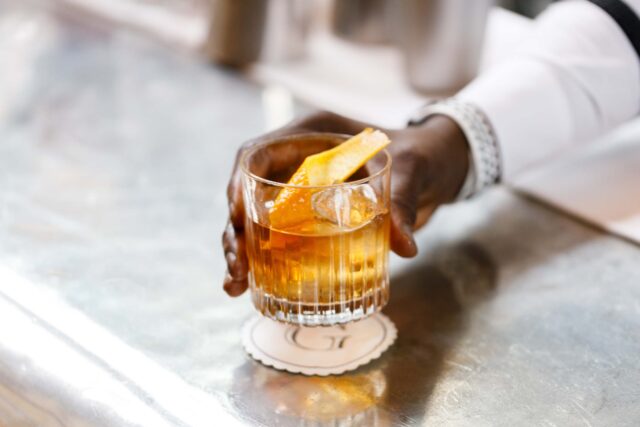 An elegant crystal coupe glass showcasing a premium craft cocktail in East London.