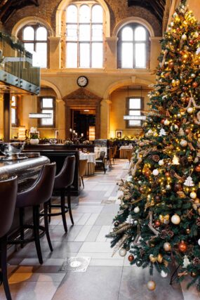 A beautifully decorated large Christmas tree inside the elegant, high-ceilinged dining room of Galvin La Chapelle restaurant.