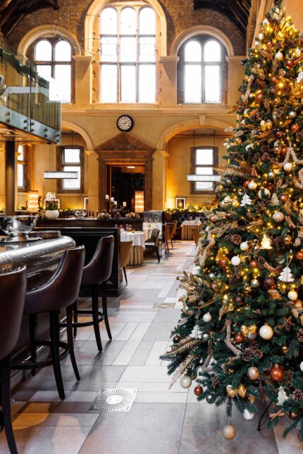 A beautifully decorated large Christmas tree inside the elegant, high-ceilinged dining room of Galvin La Chapelle restaurant.