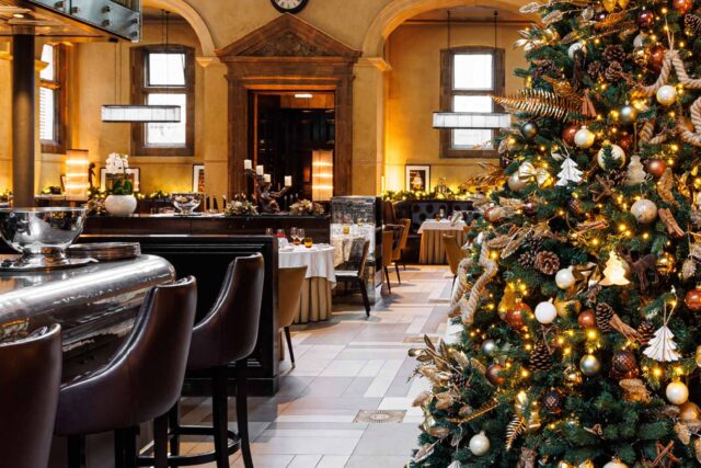 A beautifully decorated large Christmas tree inside the elegant, high-ceilinged dining room of Galvin La Chapelle restaurant.